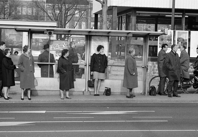 835231 Afbeelding van wachtende mensen bij een abri aan de Tunnelweg te Utrecht; rechts een deel van het V.V.V. kantoor.